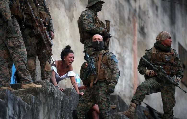 A woman reacts next to the body of a person who was shot near Sao Carlos slums complex during a police operation after heavy confrontations between drug gangs in Rio de Janeiro, Brazil. REUTERS/Ricardo Moraes  